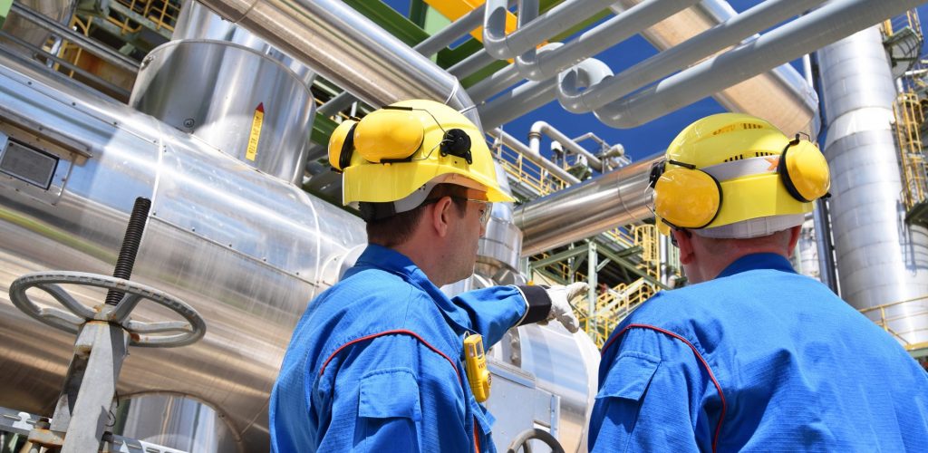 Arbeiter in einer Industrieanlage - Raffinerie zur Verarbeitung von Erdl // Workers in an industrial plant - refinery for processing crude oil
